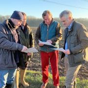 James Cartlidge, right, studying plans to put new pylons across south Suffolk with local residents.